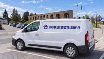 Valge kaubik Saue vallavalitsuse maja ees parkivate autode rea kõrval, küljel kodukoristustallinn.ee kiri, Saue eramus pestakse esiku põrand kaks korda, sest aiamuld kantakse jalanõudega sisse.